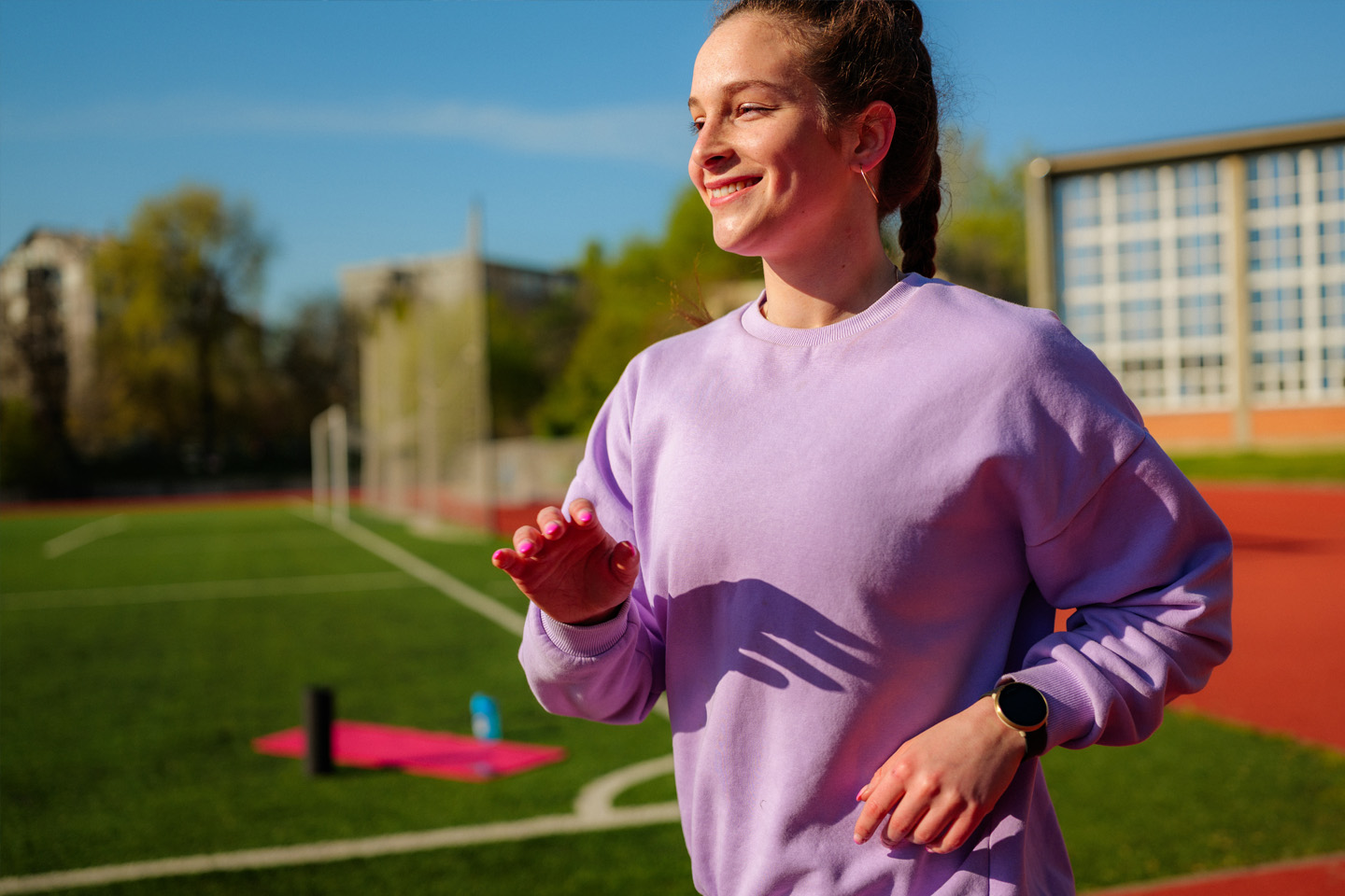 A woman runs and is smiling in the sun